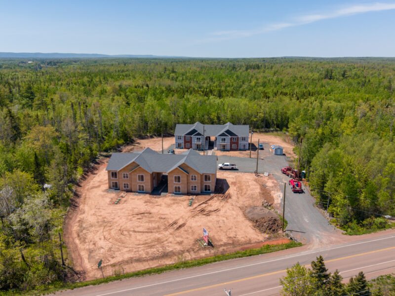 Creamery Landing site from the highway in Tatamagouche, a sheathed building in front of finished apartments