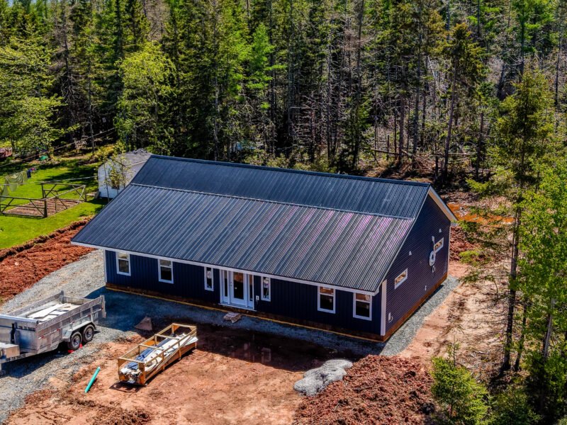 Aerial view of a new steel-roofed home and cleared lot in East Mountain, Nova Scotia