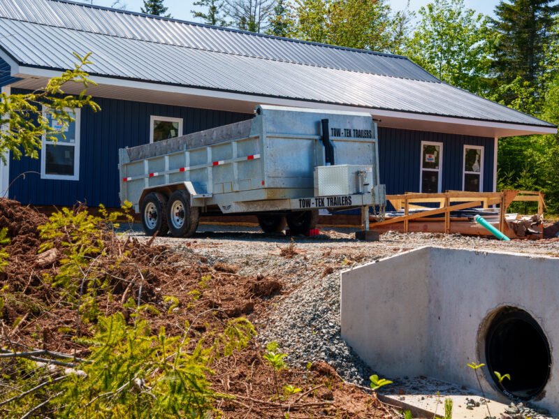 Dump trailer, driveway culvert and new navy home at the East Mountain job site