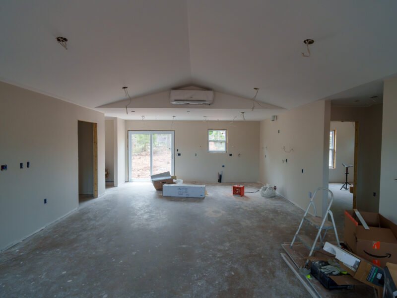 Open kitchen and living space with patio door at the drywall stage in East Mountain