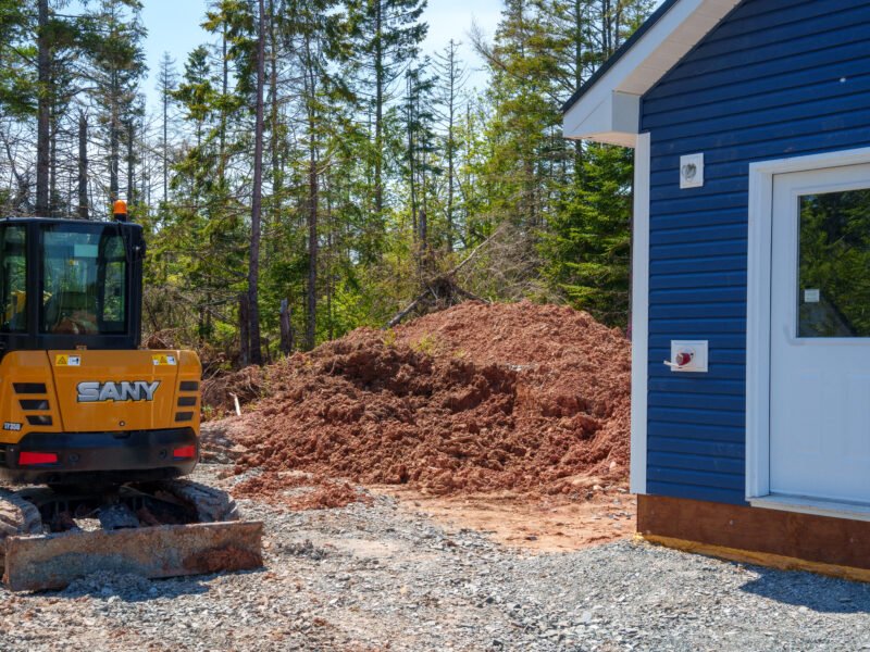 Mini excavator beside the back door of a new home in East Mountain, Nova Scotia