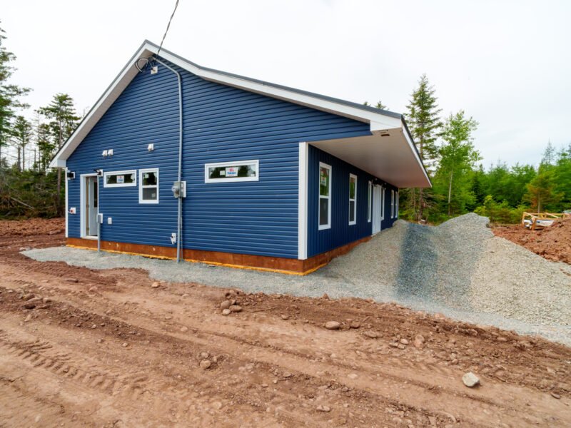 Side of a new navy home with horizontal siding and white trim in East Mountain