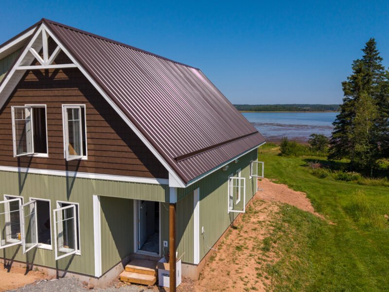Front gable with a decorative truss and sage siding on a new home in Bayhead, Nova Scotia