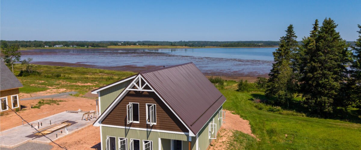 New waterfront home with a brown steel roof overlooking Tatamagouche Bay in Bayhead, NS